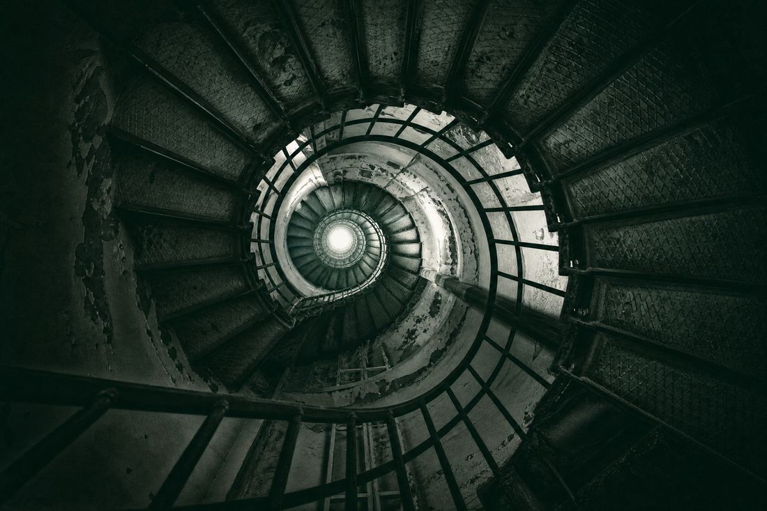 High-contrast image of a vertical shaft with ladders and hanging cables