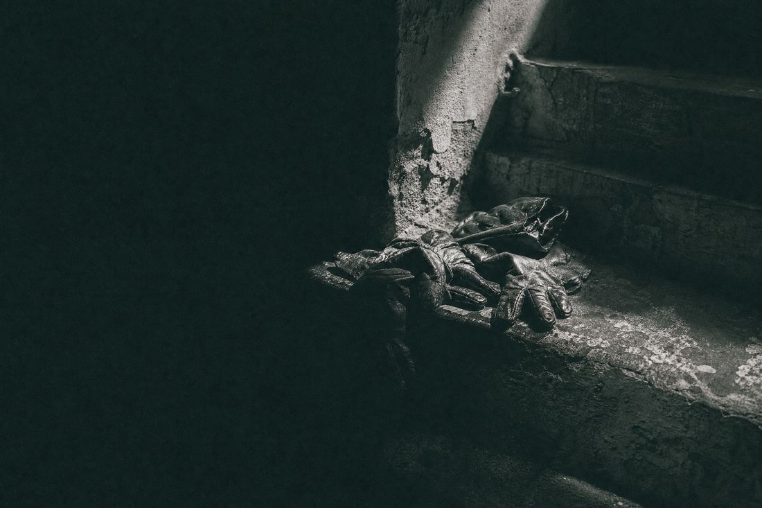 High-contrast image of a lone figure on a stone bridge under heavy fog