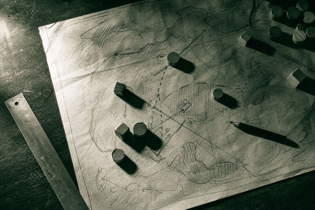 Overhead high-contrast image of a hand-drawn campaign map with pins and string
